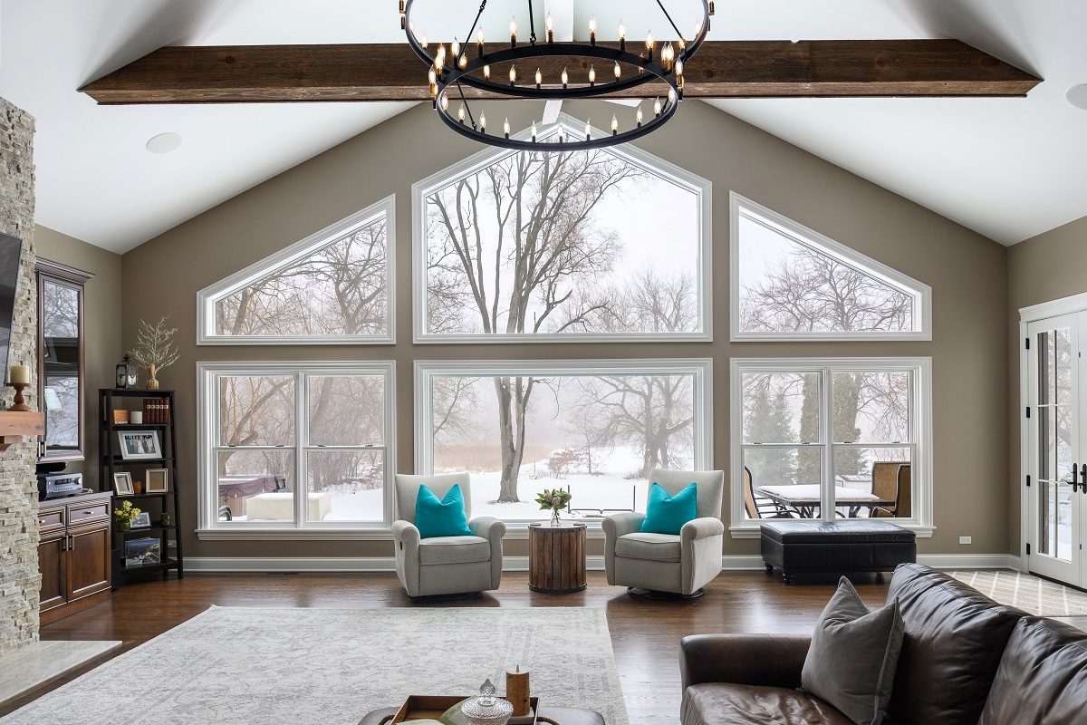 Vaulted great room with exposed beams and a wall of windows